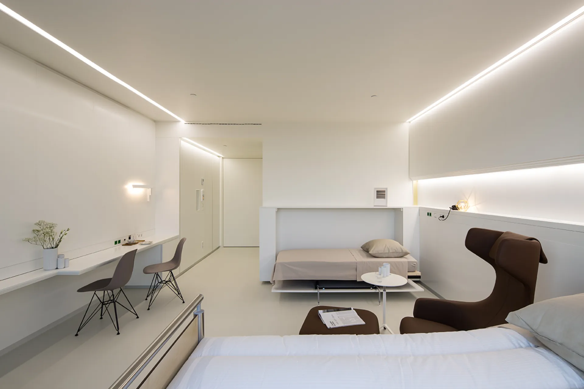A patient room with generous storage space in the supply unit behind the head of the patient bed